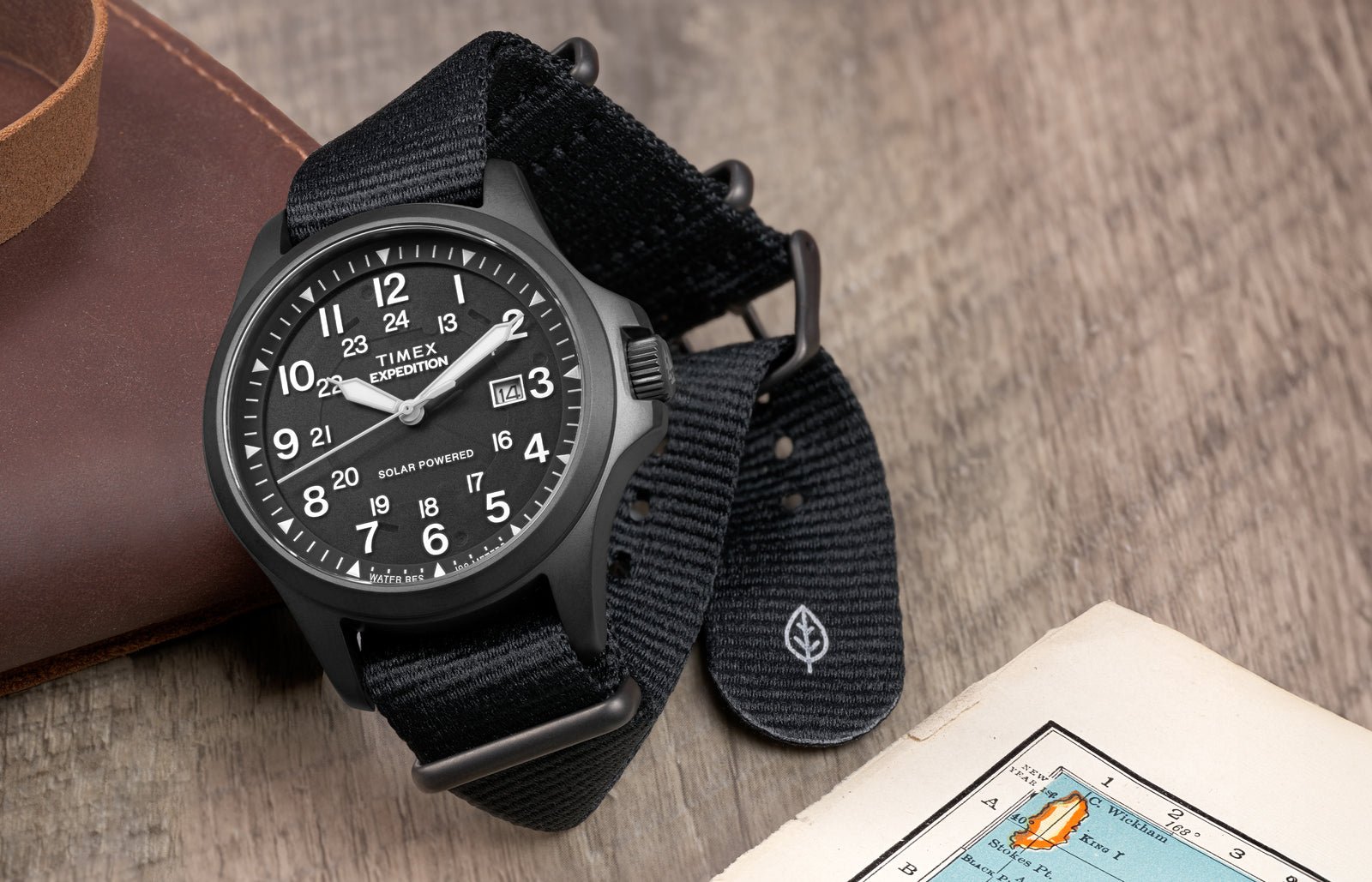 Timex Expedition Field Post Solar watch on wood surface next to map (lifestyle photo)